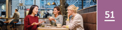 Lesson 51. Three women converse happily in a coffee shop.