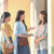 Una estudiante de la Biblia y su maestra predicándole a una mujer delante de su puerta.