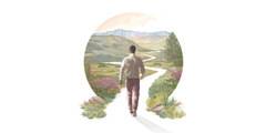 A man starting to walk down a winding path surrounded by beautiful vegetation, hills, and mountains.