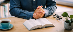 Мужчина молится перед чтением Библии.