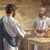 Jesus approaching his brother James in a carpentry shop. James is surprised to see him.