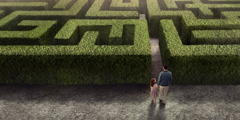 Isä ja tytär seisovat labyrintin sisäänkäynnillä.