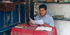 یکی از شاهدان یَهُوَه در حال مطالعهٔ مجلّهٔ برج دیده‌بانی به زبان بومی