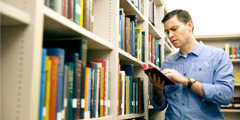 Um homem examina a Bíblia numa biblioteca