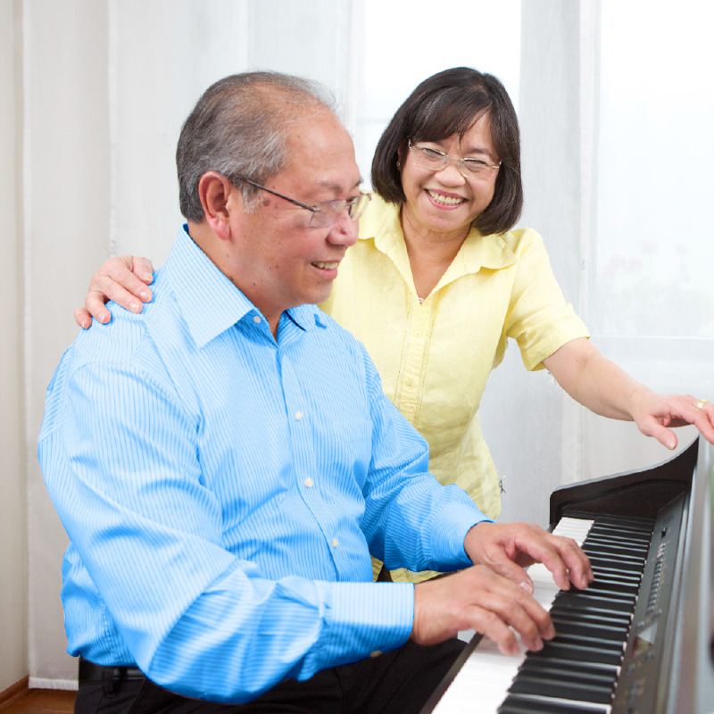 Un homme âgé ravi de jouer du piano pour sa femme