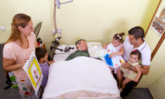 Félix Alarcón recevant la visite d’une famille ; les enfants lui montrent des dessins