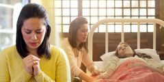 Uma mulher ora, pensando em sua mãe que está doente