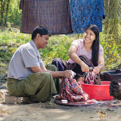 Using a tub of water, a husband helps his wife wash clothes