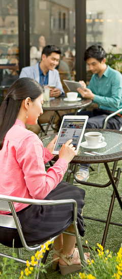 Một phụ nữ xem trang web jw.org khi ngồi ở quán cà phê ngoài trời