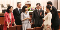 Atsushi and Michiyo Kumagai converse with others at a Kingdom Hall