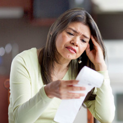 A woman looks anxiously at a receipt