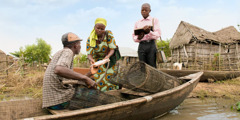 Jehovah’s Witnesses in Benin preach to a man in a canoe