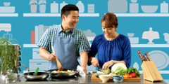 A husband and wife work together in the kitchen