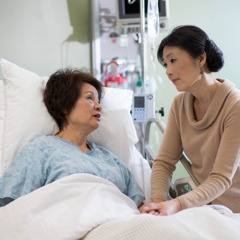 Una donna visita un malato terminale in ospedale