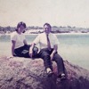 Winston and Pam Payne, in younger years, sit on top of a rock by the sea