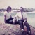 Winston a Pam Paynovi zamlada jak sedí na balvanu u moře