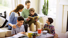 Ouders die het boek Lessen van de Grote Onderwijzer met hun kinderen doornemen