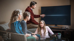 Otec rodiny svědků vypíná televizi, rodina sedí kolem