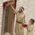 An Israelite father and his son splashing the doorframe of their home with blood.