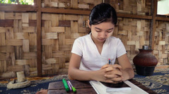 A scene from the video ‘Youths​—Taste and See That Jehovah Is Good.’ A young sister prays before starting her personal study.