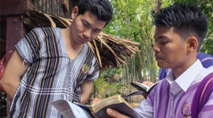 A scene from the video ‘Youths​—Taste and See That Jehovah Is Good.’ A pioneer brother shares a scripture with a man in the Karen (S’gaw) language.