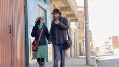 A scene from the video ‘Field Missionaries​—Workers in the Harvest.’ A field missionary couple walking down a street in the witnessing work.