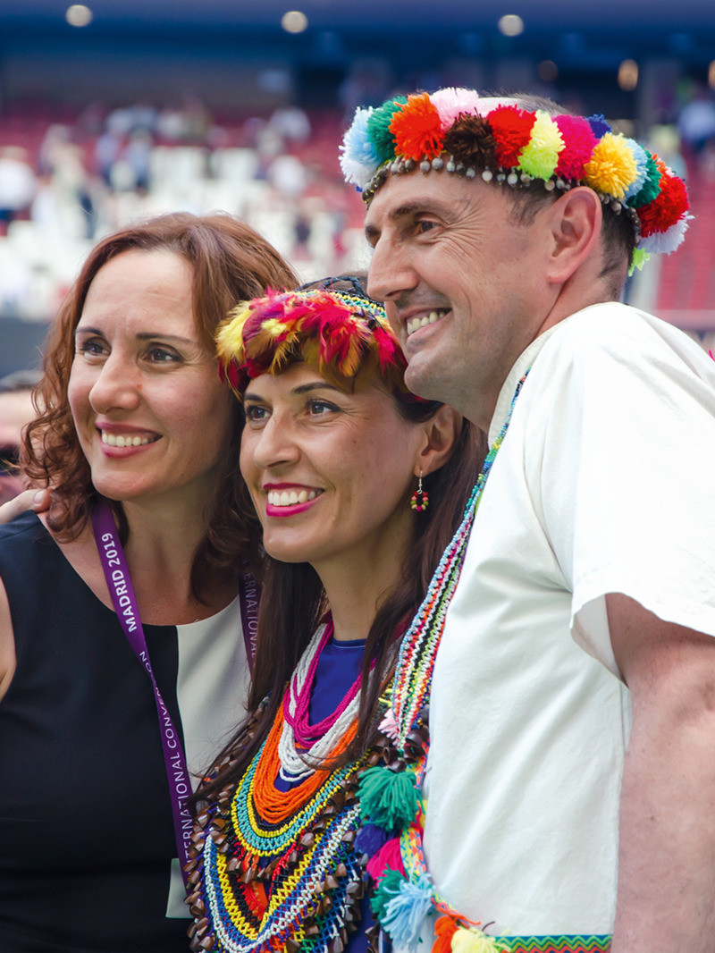 Delegates from different cultural backgrounds posing together for a picture at an international convention.