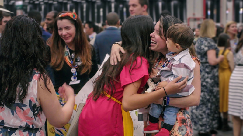 A scene from the video ‘‘Love Never Fails’! International Conventions.’ Delegates and local brothers and sisters hug and welcome one another at an international convention.