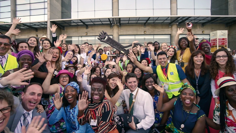 A scene from the video ‘‘Love Never Fails’! International Conventions.’ Local brothers and sisters pose with visiting delegates for a group photo.