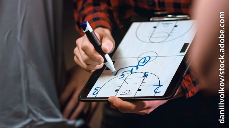 Σκηνή από το βίντεο «Τα Εφηβικά μου Χρόνια​—Πώς Μπορώ να Μιλάω με τους Γονείς Μου;» Προπονητής του μπάσκετ ζωγραφίζει σε έναν πίνακα τη στρατηγική της ομάδας του.