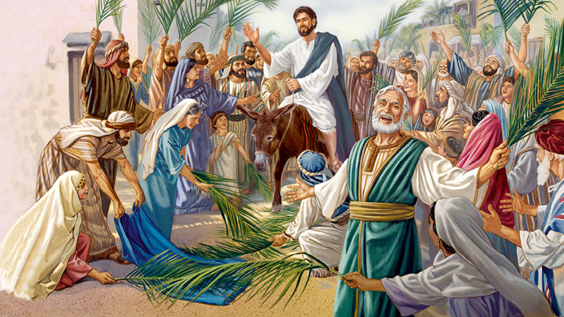 Ο Ιησούς κάθεται σε ένα γαϊδουράκι. Το πλήθος απλώνει στον δρόμο εξωτερικά ρούχα και φοινικόκλαδα.