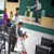 Brothers and sisters before a congregation meeting. 1. Sisters greet and talk with one another. 2. A brother adjusts a microphone on the platform. 3. A brother and his young son clean.