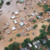 A scene from the video “Devastating Flooding in Brazil.” An aerial view of partially submerged houses and trees in a flooded neighborhood.