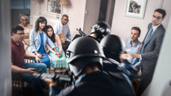 En liten grupp Jehovas vittnen har ett möte i ett hem när poliser med skyddsvästar och vapen stormar in.