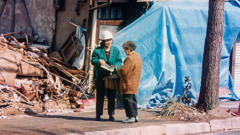A sister wearing a hard hat, witnessing to a woman after a natural disaster.