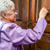 An elderly sister knocking on a door while in the ministry.