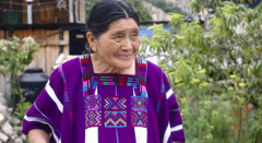 Stseen videost „Ärgu hääbugu sinu armastus koguduses. Armasta eakaid”. Õde Paulina Sántiz Gómez seisab naeratades oma maja ees.