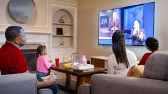 The family watching a JW Broadcasting program.