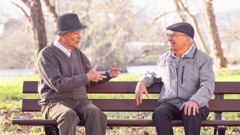 En un parque, un hermano de edad avanzada conversa con un hombre que está sentado a su lado.