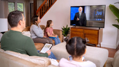 A family watching a JW Broadcasting program.