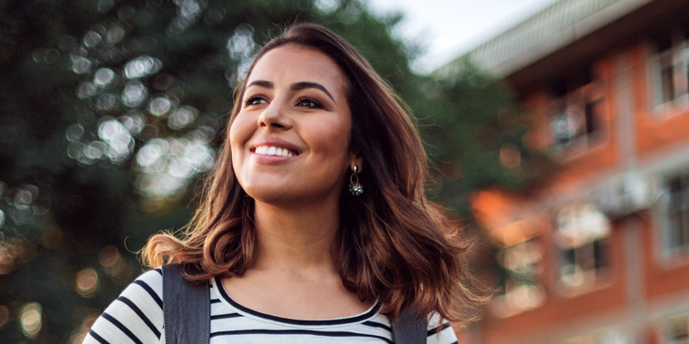 A young woman smiling, looking upward.