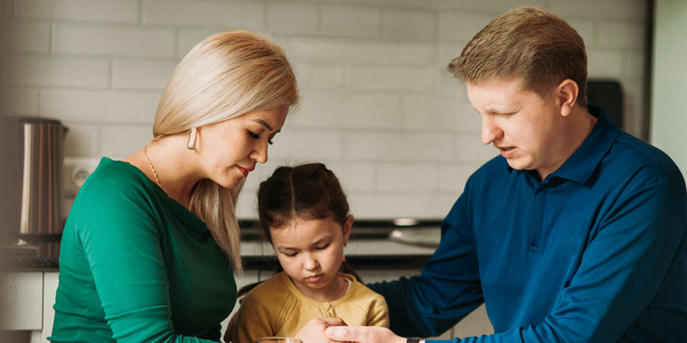 A family praying together.