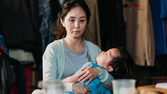 Ista žena na kraju dana, tužna i iscrpljena, drži u naručju sina.