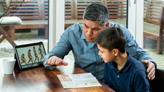 A father discussing with his son the brochure “The Origin of Life​—Five Questions Worth Asking.”