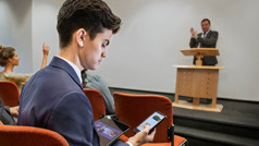 A brother responding to text messages during a congregation meeting.