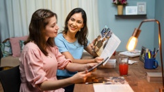 Two young sisters studying together an article from “The Watchtower.”