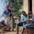 En glad familie sidder ude foran deres hus. De bor meget beskedent, og moren står og laver et enkelt måltid mad over åben ild. Faren sidder og læser i “Min bog om Bibelen” sammen med deres to børn.