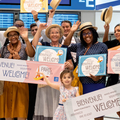 Happy brothers and sisters at an airport welcoming delegates to an international convention in Paris.