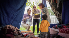 Et ægtepar kommer med mad og andre forsyninger til en mor og hendes søn der bor midlertidigt i et telt.
