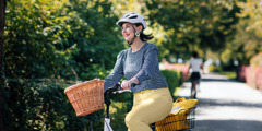 Una donna sorridente in bicicletta.